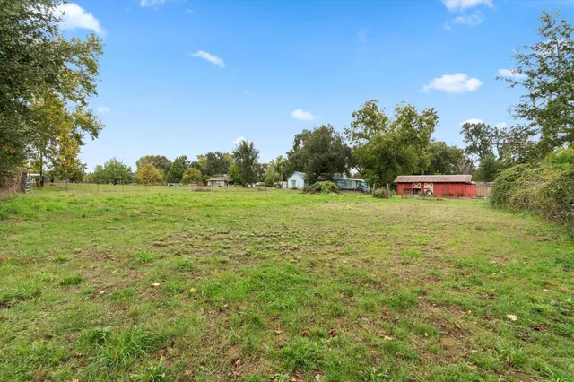 a view of a field with trees in the background