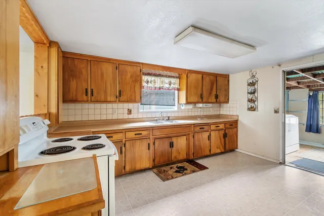 a kitchen with granite countertop a sink cabinets and window
