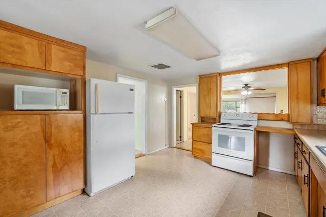 a kitchen with white cabinets and white appliances