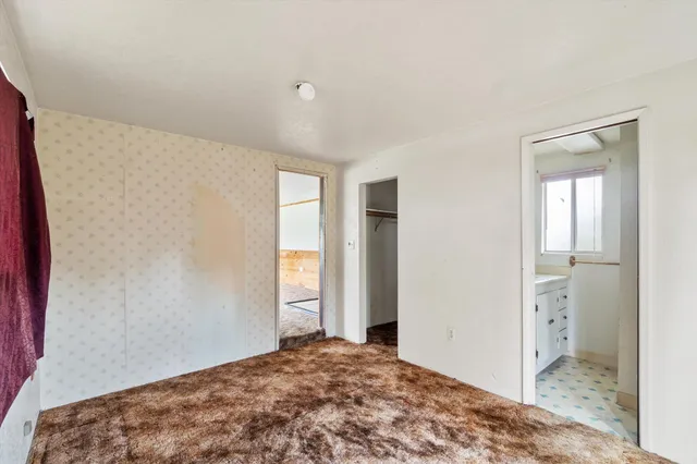 a view of a bedroom with closet and window