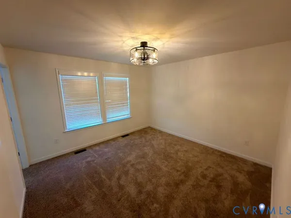 an empty room with windows and ceiling fan