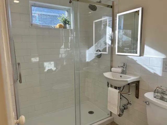a bathroom with a sink a toilet and shower