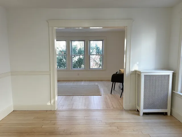 a view of a room with wooden floor and a chair