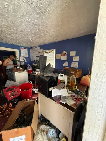 a work room with furniture a rug and a window