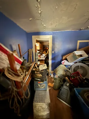 a bedroom with bed and the view of living room