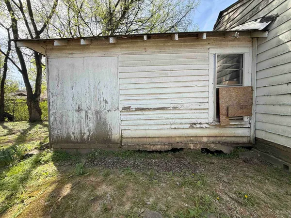a view of house with backyard and wooden fence