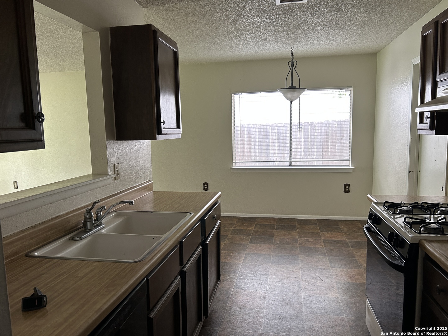 5938 Kissing Oak Street San Antonio, TX 78247 - Photo 6 of 11 a kitchen with a sink stove and microwave