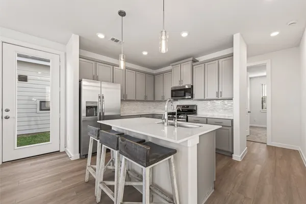 a kitchen with refrigerator a sink and chairs