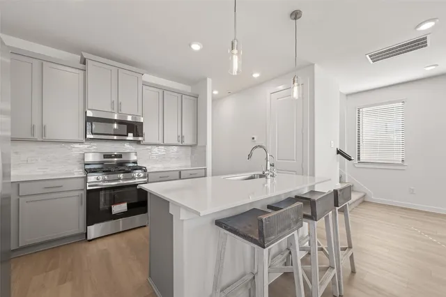 a kitchen with a sink stove and cabinets