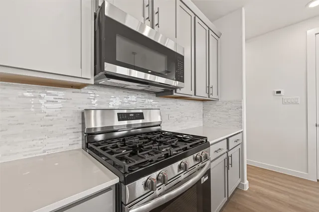 a kitchen with stainless steel appliances a sink a stove and a microwave