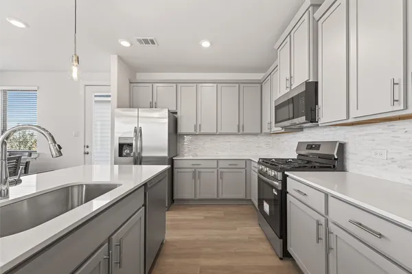 a kitchen with a sink stove and cabinets