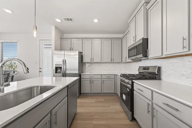 a kitchen with a sink stove and cabinets