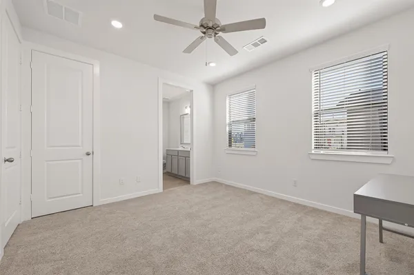 a view of a livingroom with a ceiling fan and windows