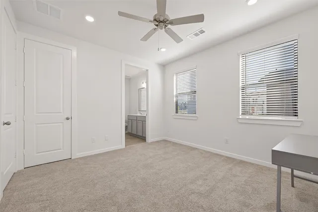 a view of a livingroom with a ceiling fan and windows