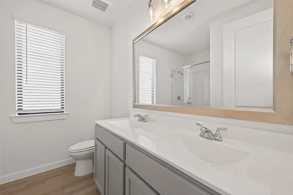 a bathroom with a granite countertop sink a toilet and a mirror