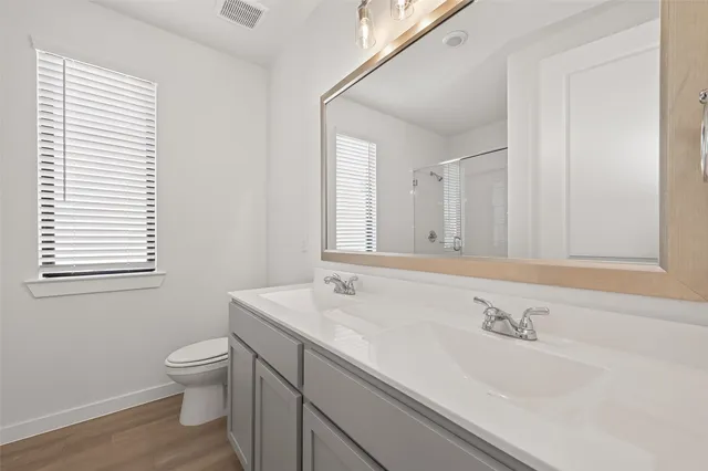 a bathroom with a granite countertop sink a toilet and a mirror