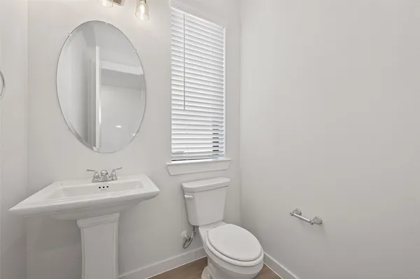 a bathroom with a toilet a sink and a mirror