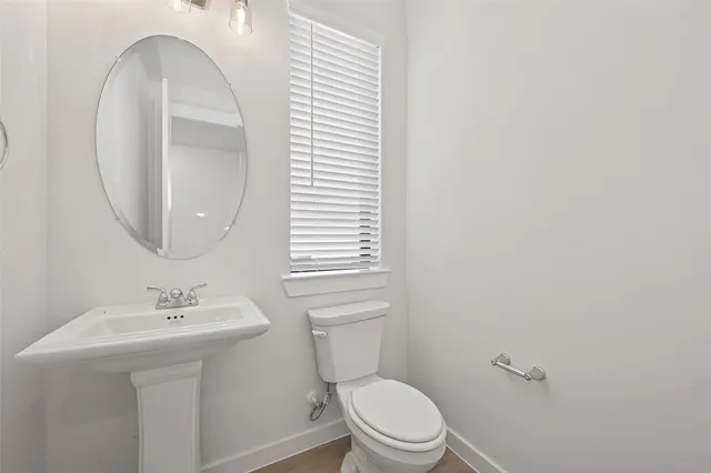 a bathroom with a toilet a sink and a mirror