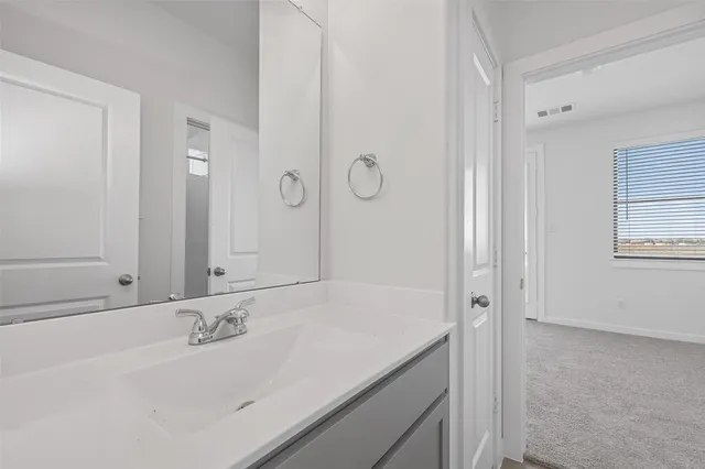 a bathroom with a granite countertop sink and a mirror