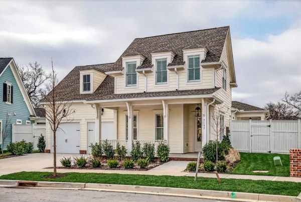 a front view of a house with a yard and potted plants