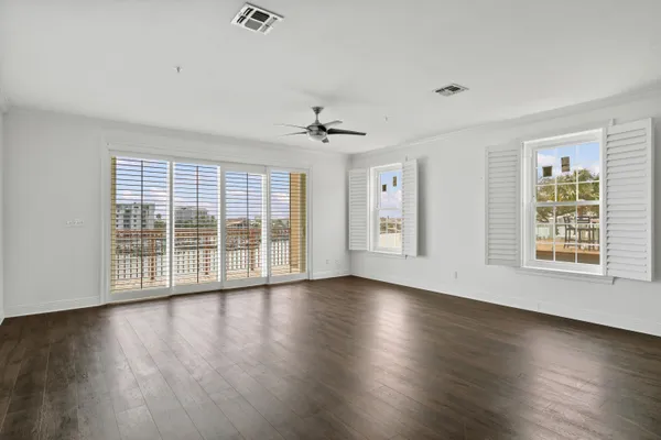 a kitchen with stainless steel appliances granite countertop a refrigerator a sink dishwasher a stove and white cabinets with wooden floor