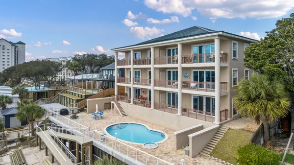 a front view of a house with swimming pool and outdoor seating