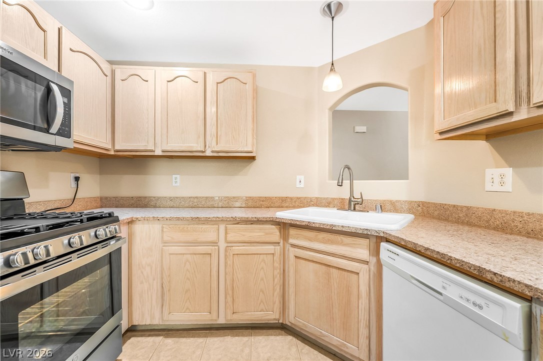 2050 West Warm Springs Road, Unit 2411 Henderson, NV 89014 - Photo 15 of 37 A well-appointed kitchen features ample cabinetry, stone-look counters, and essential appliances for daily living.