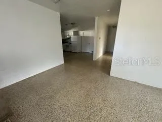 an empty room with wooden floor windows and ceiling fan