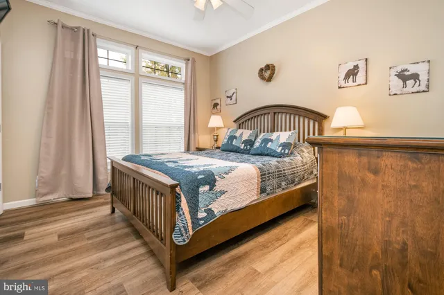 a kitchen with stainless steel appliances kitchen island granite countertop a refrigerator a stove a dining table and chairs with wooden floor