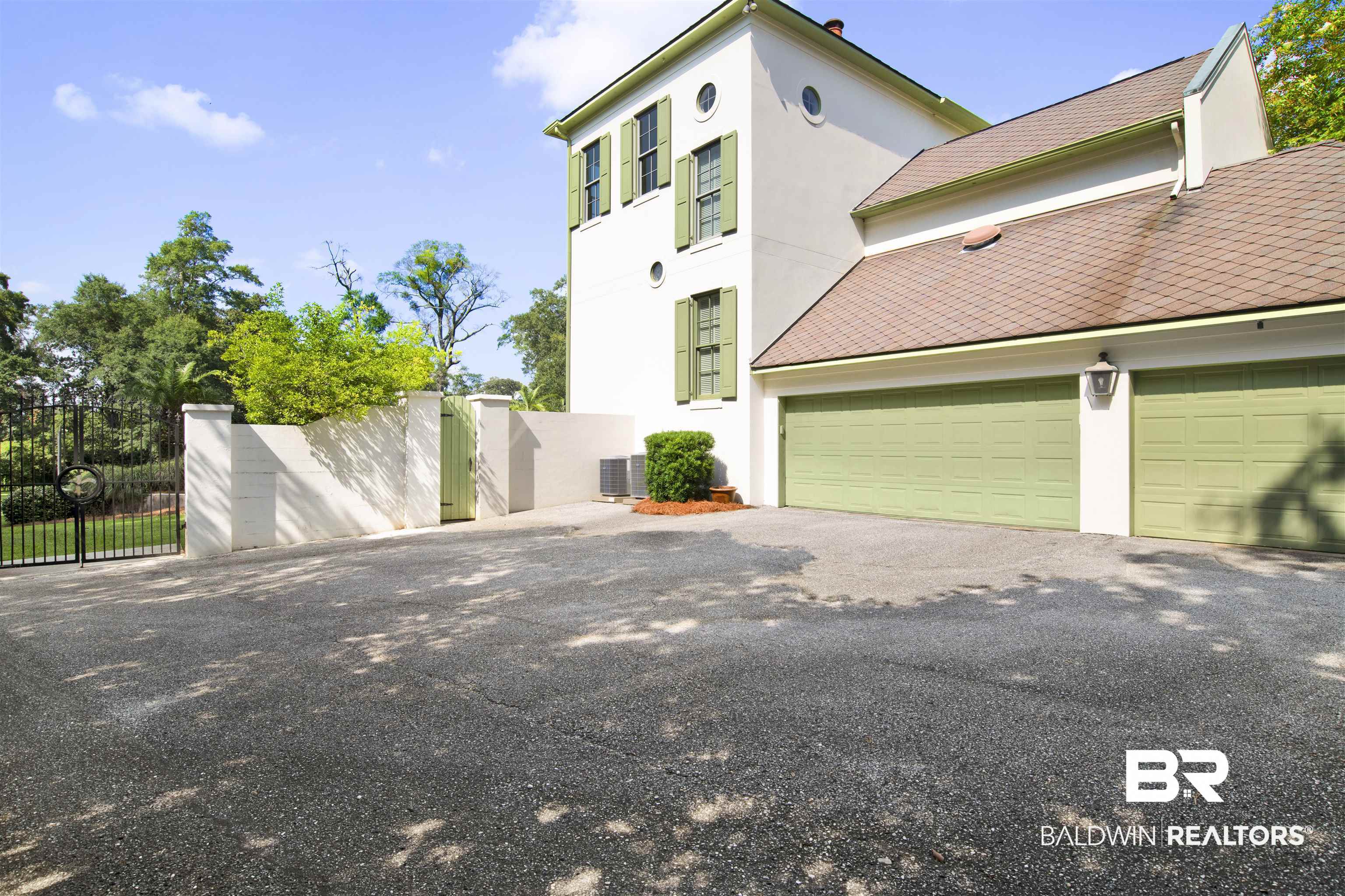 3816 Austill Lane Mobile, AL 36608 - Photo 71 of 80 View of property exterior featuring stucco siding, driveway, a gate, and an attached garage