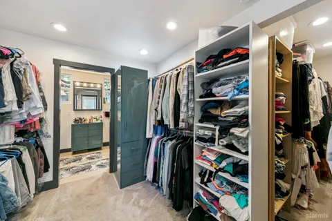 a view of walk in closet with clothes and shoes