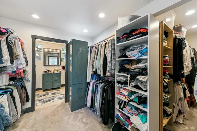 a view of walk in closet with clothes and shoes