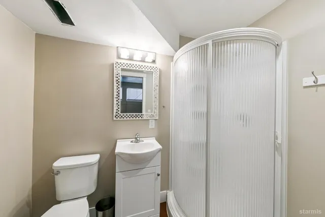 a bathroom with a toilet sink and mirror