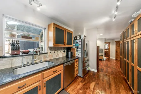 a kitchen with stainless steel appliances granite countertop a refrigerator and a sink