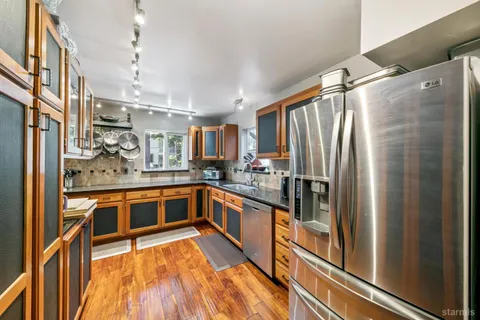 a kitchen with stainless steel appliances granite countertop a refrigerator and a sink