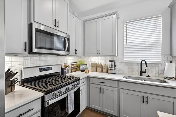 a kitchen with cabinets stainless steel appliances a sink and a window