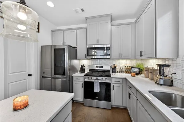 a kitchen with stainless steel appliances a stove a sink and a refrigerator