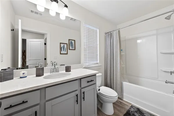 a bathroom with a double vanity sink toilet mirror and bathtub