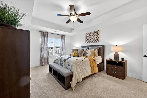 a spacious bedroom with a bed and a ceiling fan