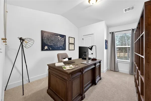 a view of a workspace with furniture and a window
