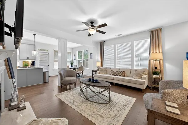 a living room with furniture and a large window with wooden floor