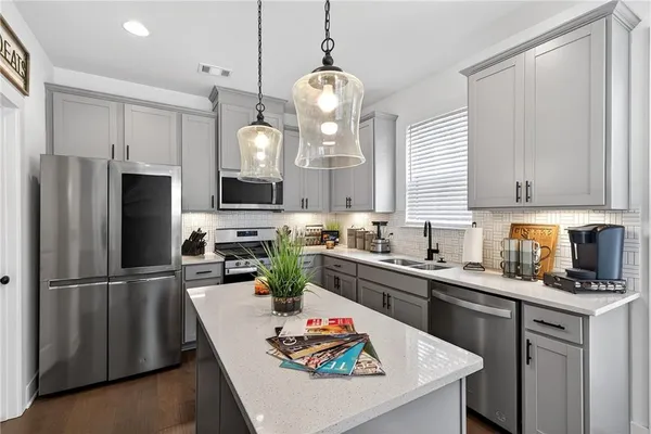 a kitchen with granite countertop a sink stainless steel appliances and cabinets