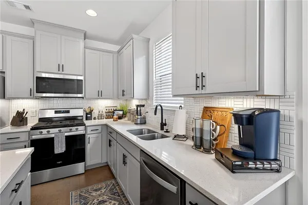 a kitchen with a sink a stove and cabinets