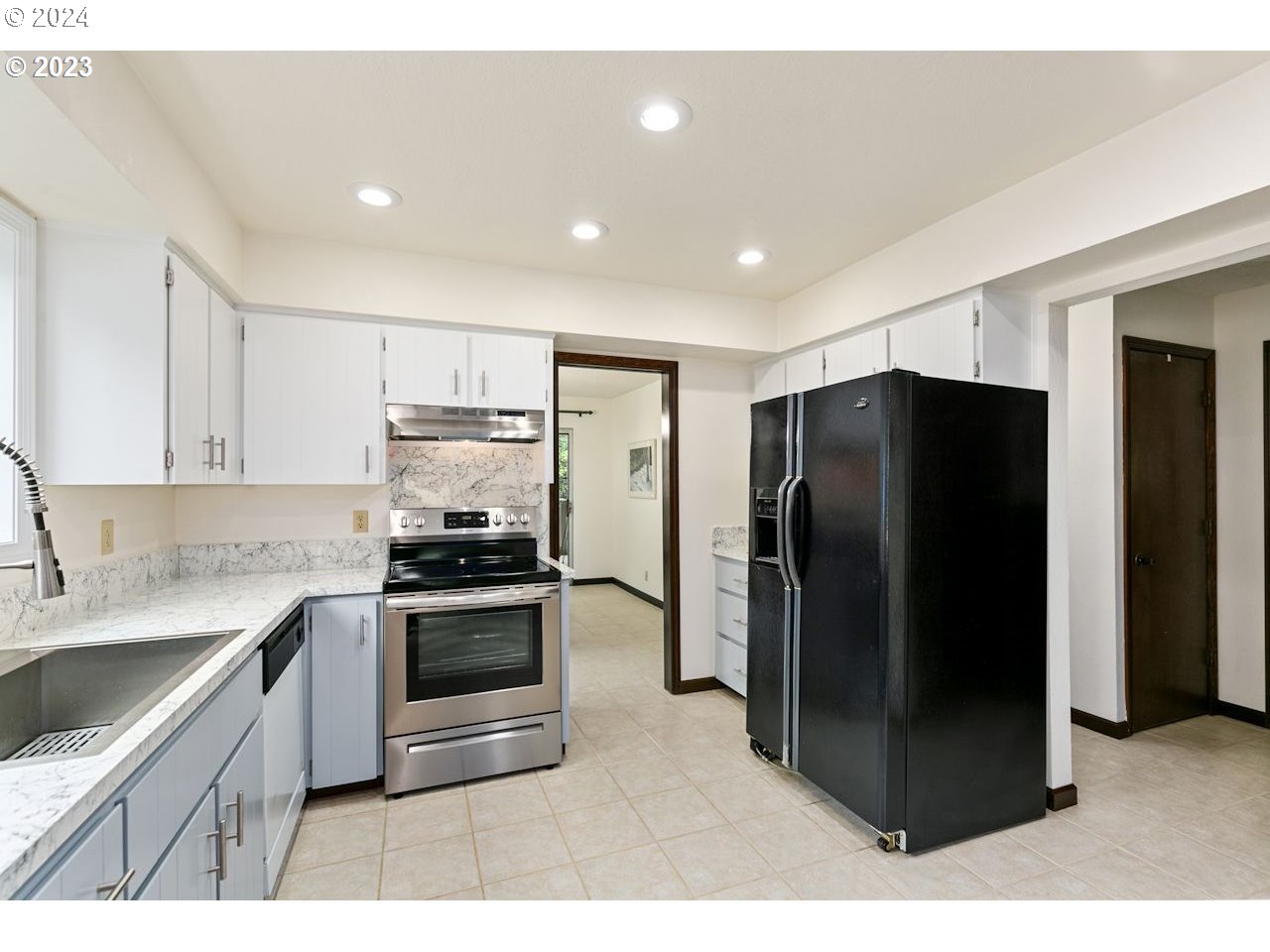3318 Northwest 203rd Street Ridgefield, WA 98642 - Photo 7 of 28 a kitchen with stainless steel appliances granite countertop a refrigerator and a sink