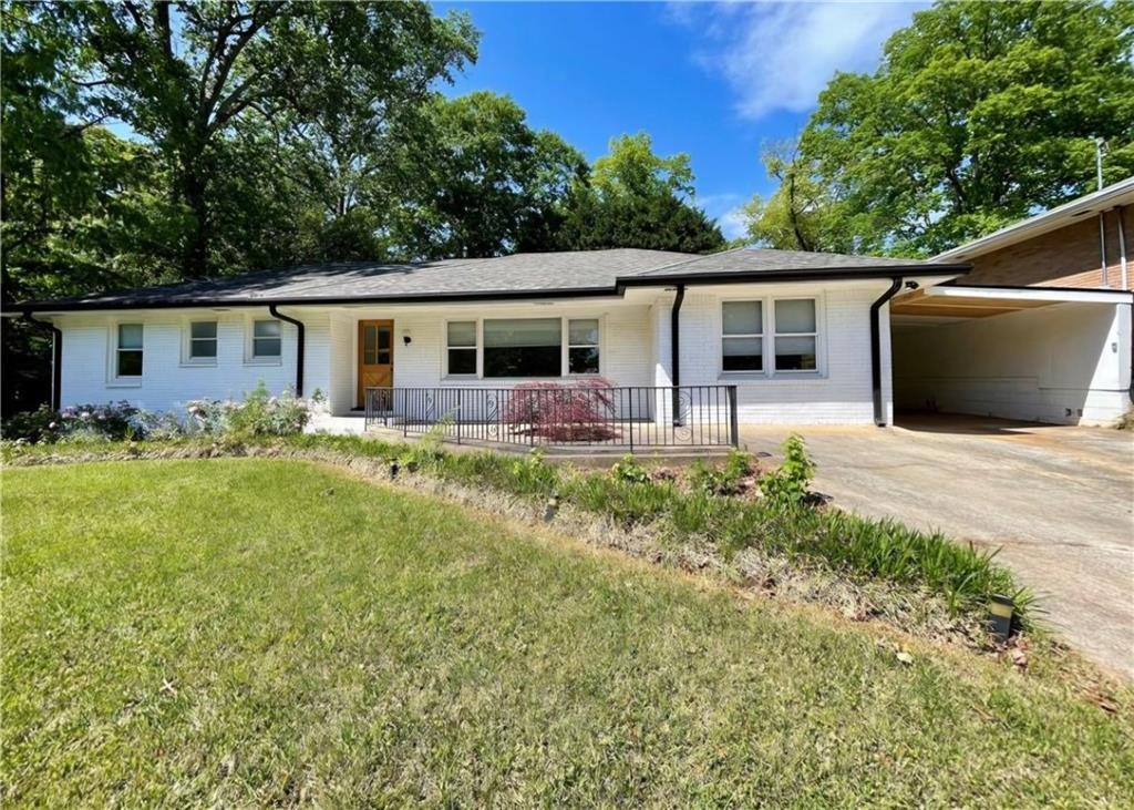 a front view of house with yard and trees in the background