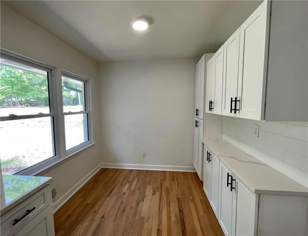 2682 Pineland Avenue Atlanta, GA 30340 - Photo 8 of 11 a view of a hallway to an empty room with wooden floor and a window