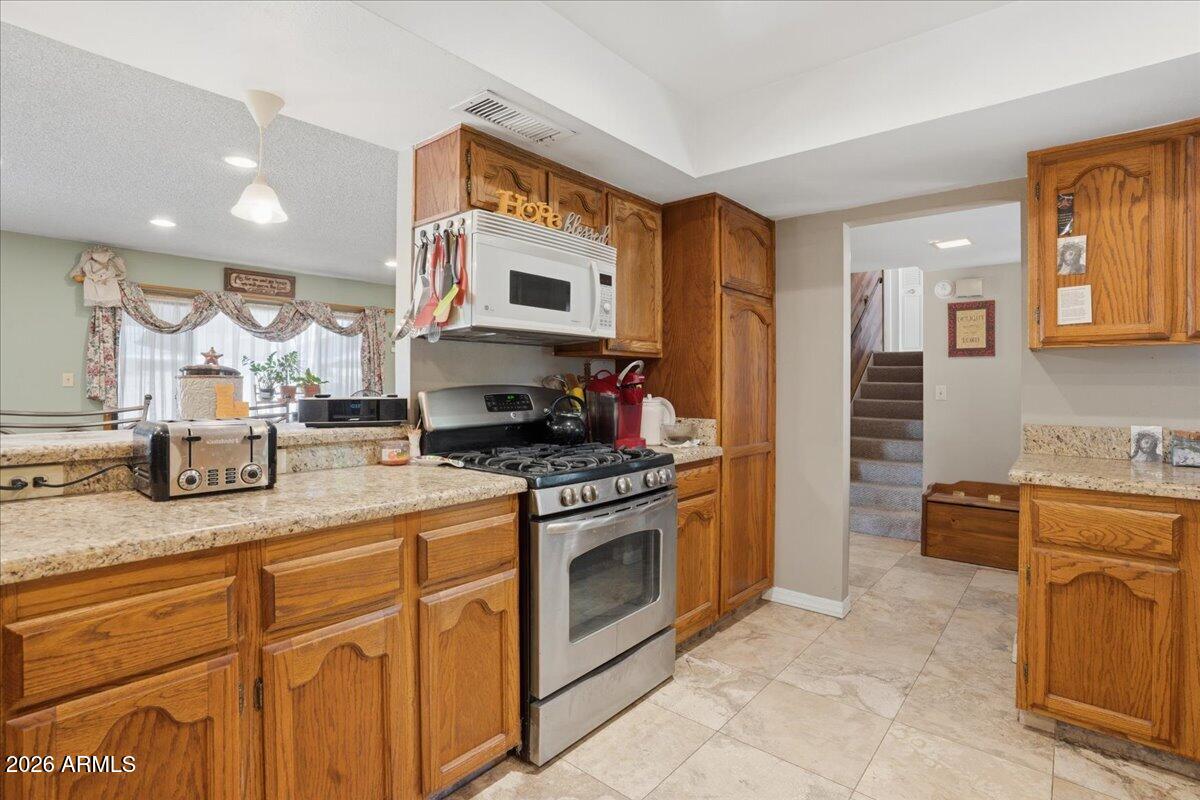 3922 South Poplar Street Tempe, AZ 85282 - Photo 14 of 41 a kitchen with stainless steel appliances granite countertop a stove a sink and a refrigerator