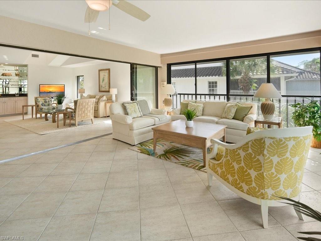 770 Eagle Creek Drive, Unit 301 Naples, FL 34113 - Photo 13 of 46 a living room with furniture and a large window