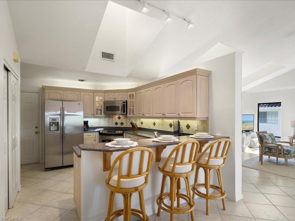 770 Eagle Creek Drive, Unit 301 Naples, FL 34113 - Photo 17 of 46 a kitchen with stainless steel appliances granite countertop a stove a sink dishwasher and a refrigerator