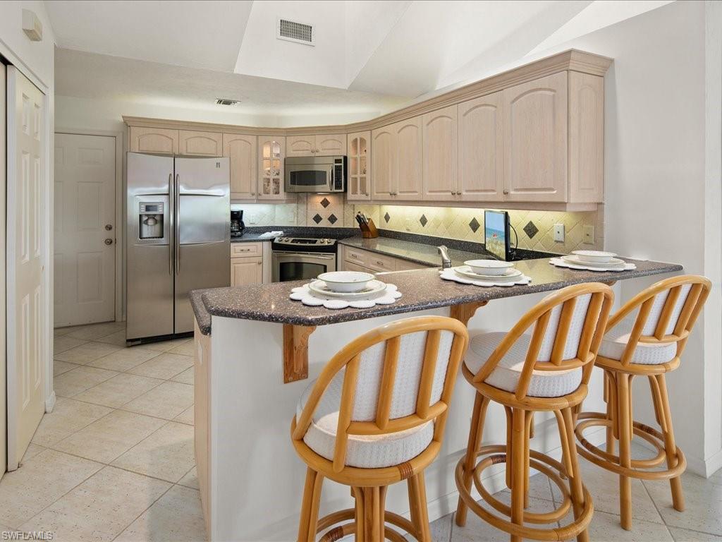 770 Eagle Creek Drive, Unit 301 Naples, FL 34113 - Photo 18 of 46 a kitchen with stainless steel appliances granite countertop a sink and cabinets